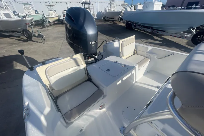 Slide: The Image of 2016 NauticStar 2110 Sport boat interior with Yamaha 150 engine, docked among other boats. - 6