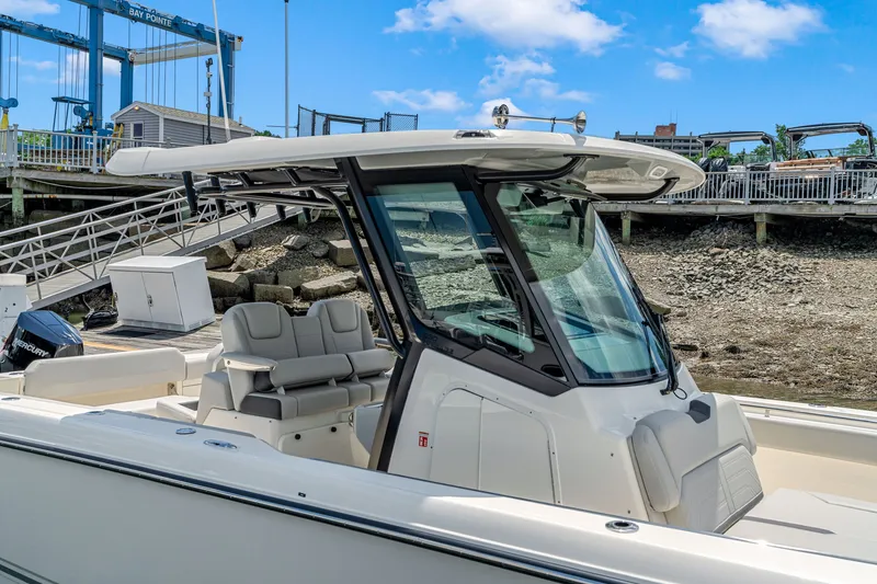 Slide: The Image of Boston Whaler 330 Outrage 2026 at dock with sleek design and comfortable seating. - 23