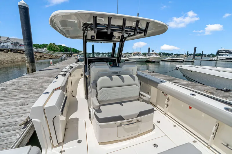 Slide: The Image of The image shows a Boston Whaler 330 Outrage boat at a dock. It features a modern design. - 11