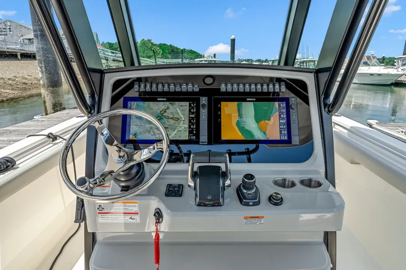 Slide: The Image of The cockpit of the 2026 Boston Whaler 330 Outrage features modern navigation systems and controls. - 19