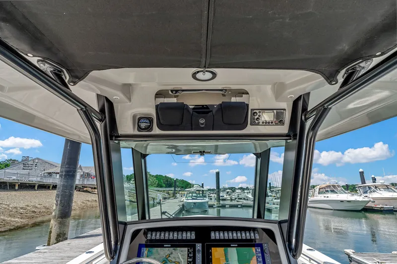 Slide: The Image of View from the helm of a Boston Whaler 330 Outrage overlooking a marina with several boats. - 21