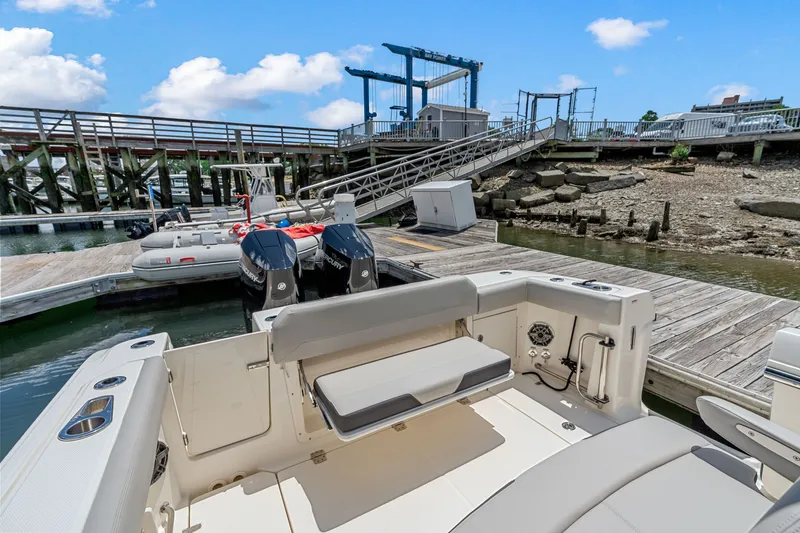 Slide: The Image of The image shows a Boston Whaler 330 Outrage boat at a dock with two outboard engines. - 10