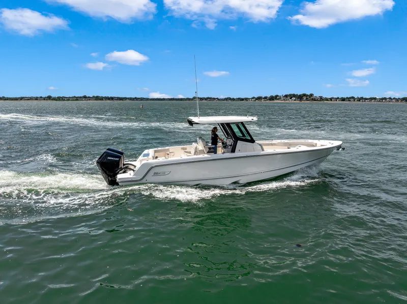 Slide: The Image of A 2026 Boston Whaler 330 Outrage cruising on calm waters under a blue sky. - 31