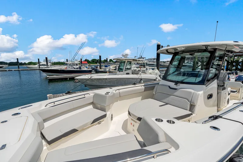 Slide: The Image of A 2026 Boston Whaler 330 Outrage docked in a marina. It features a sleek design and comfortable seating. - 26