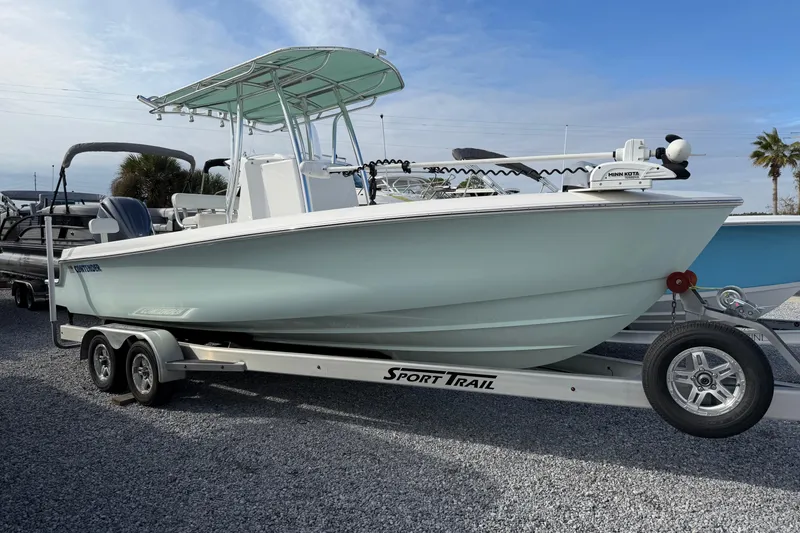 The Image of 2023 Contender 24 Sport boat on trailer, parked outdoors under blue sky. - 1