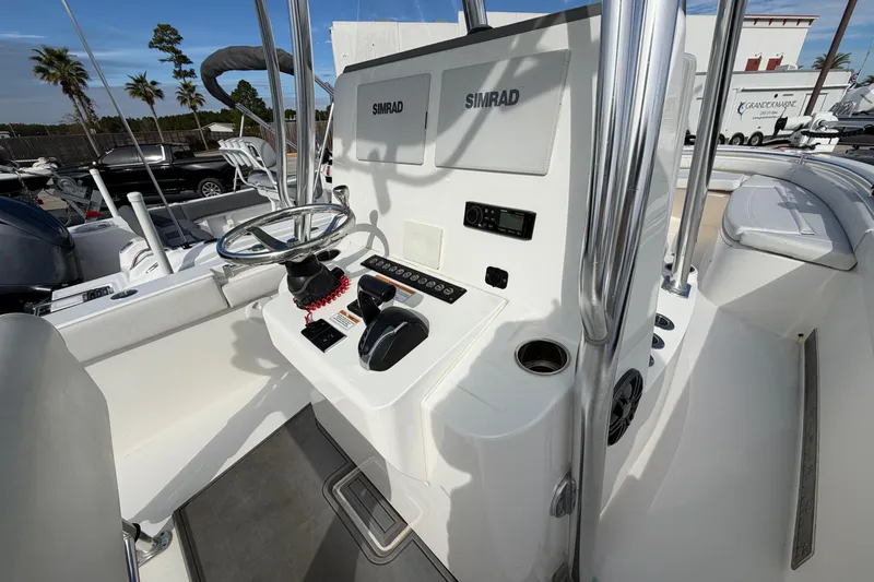 Slide: The Image of 2023 Contender 24 Sport boat console with steering wheel and Simrad electronics. - 13