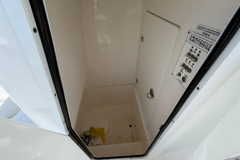 Slide: The Image of 2023 Contender 24 Sport boat storage compartment with control panel and clean interior. - 17