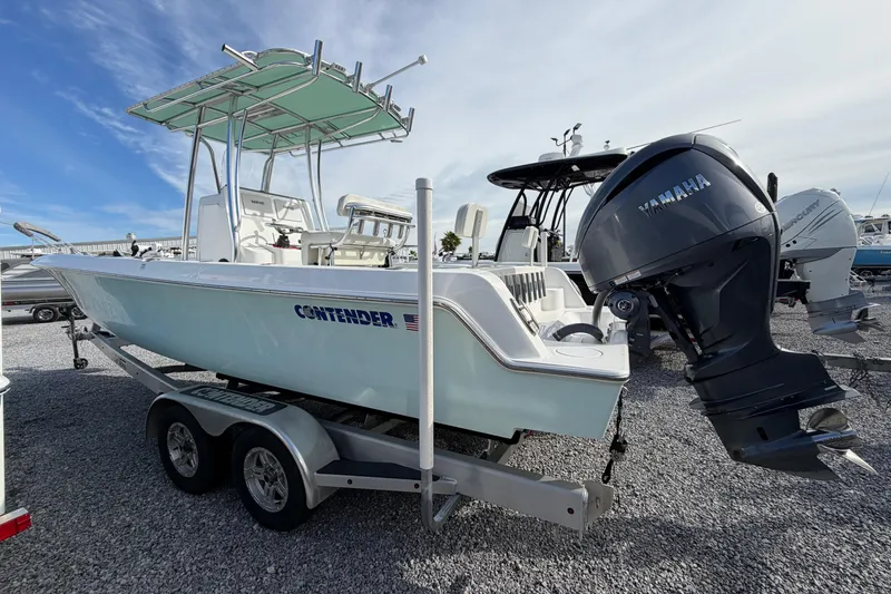 Slide: The Image of 2023 Contender 24 Sport boat with Yamaha engine on trailer, parked on gravel. - 5