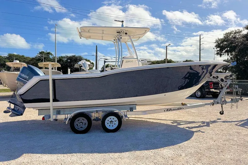 Slide: The Image of 2012 Tidewater 230 CC Adventure boat on trailer under clear sky. - 1
