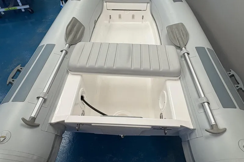 Slide: The Image of 2024 Flexboat F-12 inflatable boat displayed indoors with outboard motor. - 5