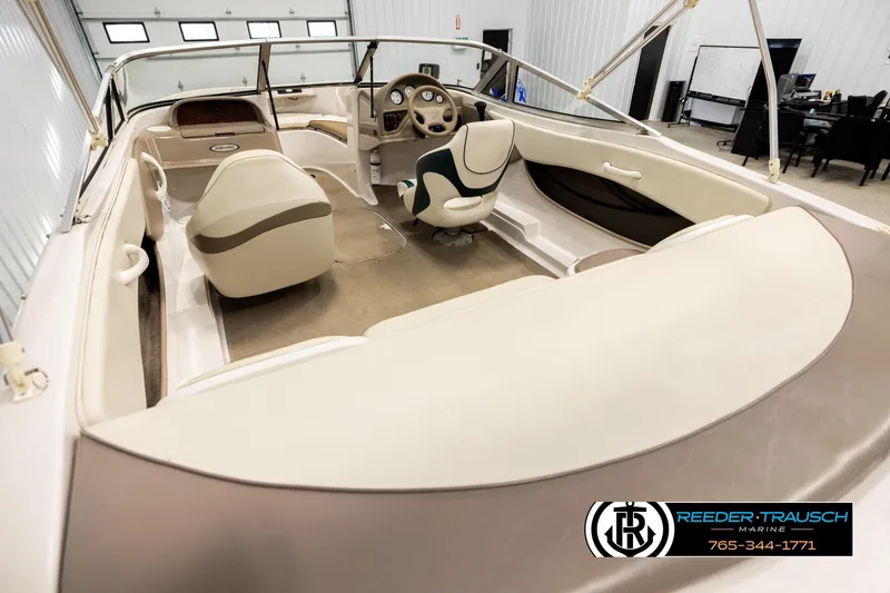 Slide: The Image of 2003 Four Winns 180 Freedom I/O boat interior with beige seating and steering wheel. - 10