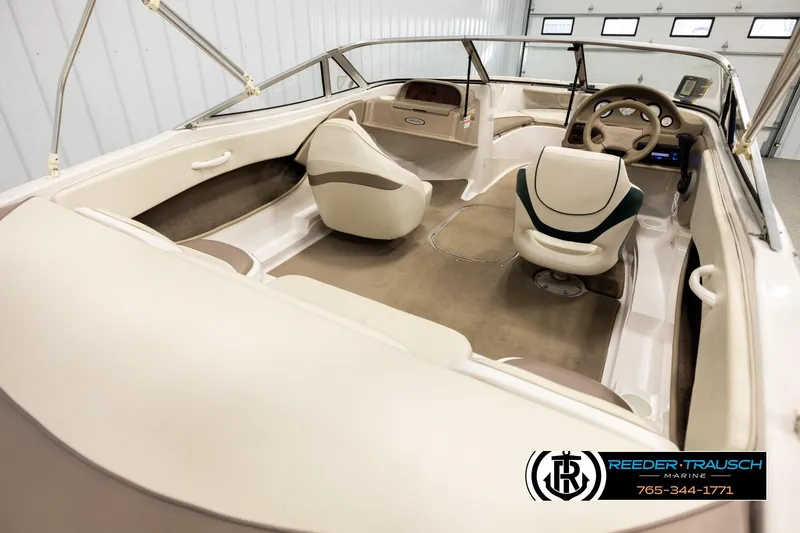 Slide: The Image of 2003 Four Winns 180 Freedom I/O boat interior with beige seating and steering wheel. - 11