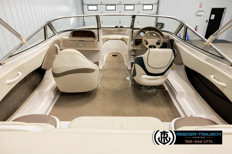 Slide: The Image of 2003 Four Winns 180 Freedom I/O boat interior with steering wheel and seating. - 12