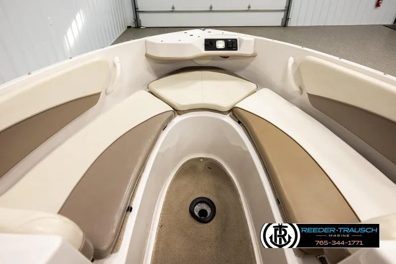 Slide: The Image of 2003 Four Winns 180 Freedom I/O boat interior with beige seating and storage compartments. - 14