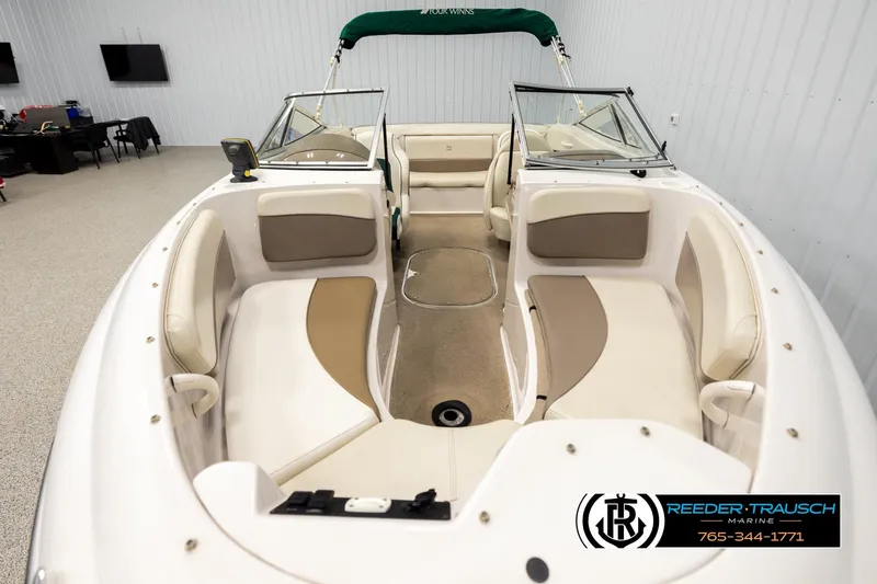 Slide: The Image of 2003 Four Winns 180 Freedom I/O boat interior with beige seating and green canopy. - 15