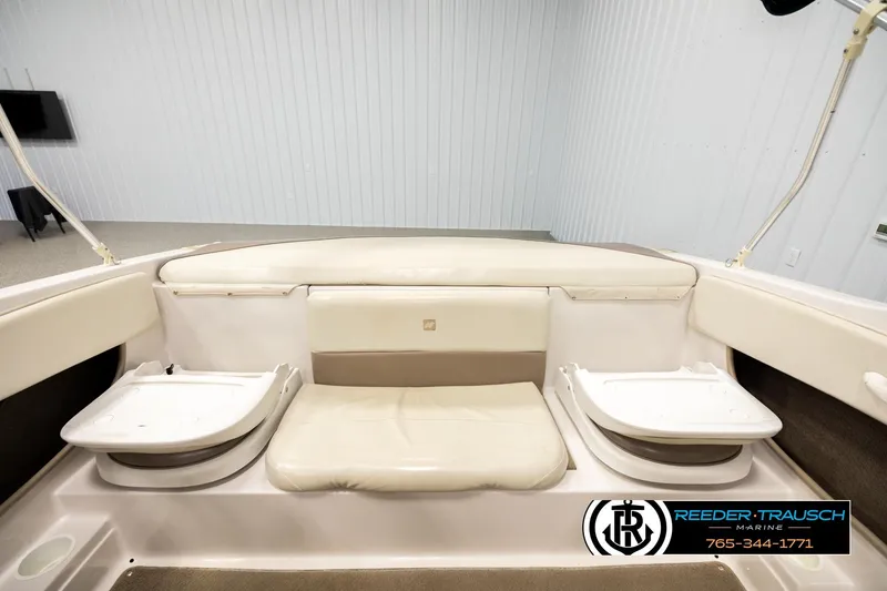 Slide: The Image of 2003 Four Winns 180 Freedom I/O boat interior with beige seating and storage compartments. - 18