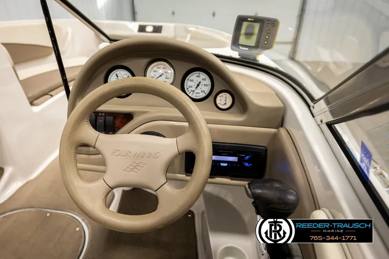 Slide: The Image of 2003 Four Winns 180 Freedom I/O boat dashboard with steering wheel and gauges. - 28