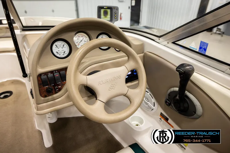 Slide: The Image of 2003 Four Winns 180 Freedom I/O boat dashboard with steering wheel and controls. - 29