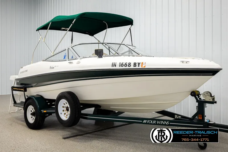 Slide: The Image of 2003 Four Winns 180 Freedom I/O boat with green canopy on trailer. - 3