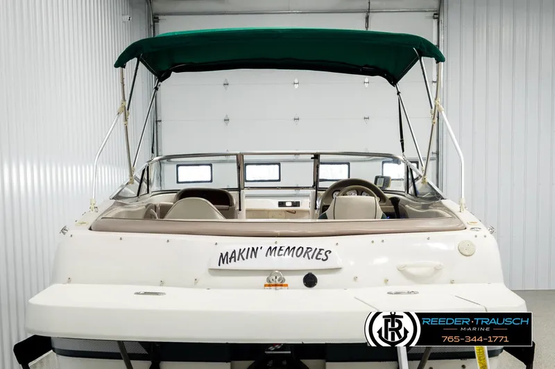 Slide: The Image of 2003 Four Winns 180 Freedom I/O boat with green canopy in storage. - 6