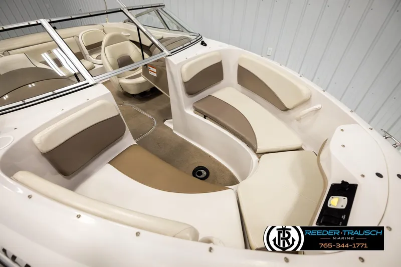 Slide: The Image of 2003 Four Winns 180 Freedom I/O boat interior with beige seating and steering console. - 8