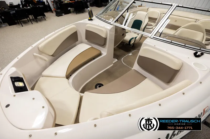 Slide: The Image of 2003 Four Winns 180 Freedom I/O boat interior with beige seating and windshield. - 9