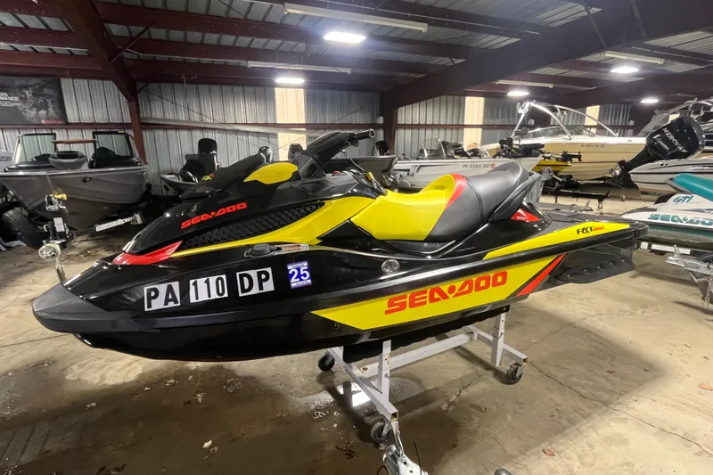 Slide: The Image of 2015 Sea-Doo RXT 260 jet ski in a storage facility, black and yellow design. - 5
