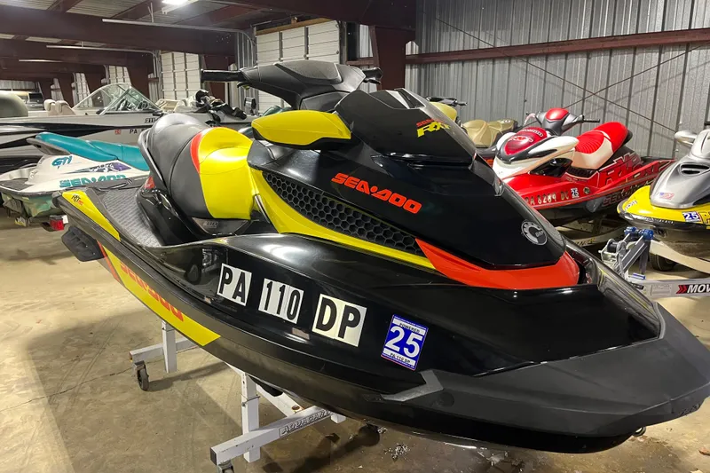 Slide: The Image of 2015 Sea-Doo RXT 260 jet ski in storage, black and yellow design. - 9