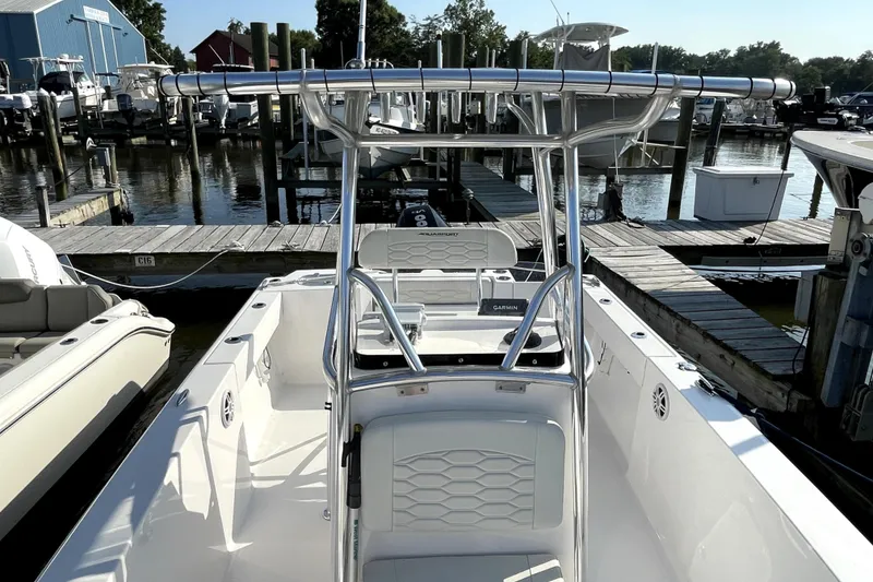 Slide: The Image of 2024 Aquasport 2200 Center Console boat docked at marina, showcasing sleek design. - 3