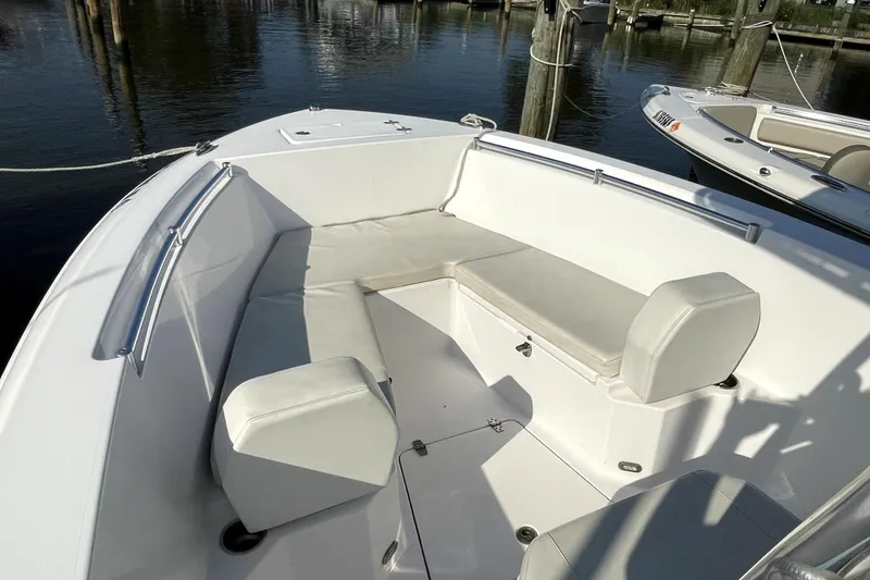 Slide: The Image of 2024 Aquasport 2200 Center Console boat with spacious seating area, docked by the water. - 5