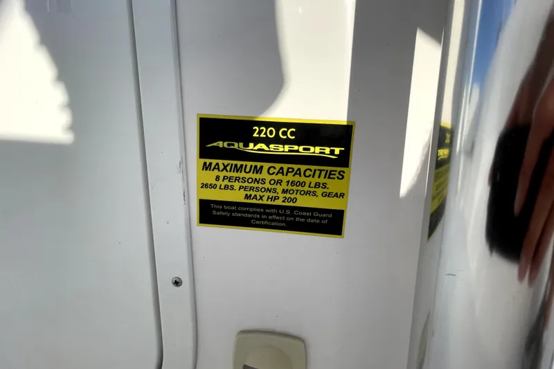 Slide: The Image of 2024 Aquasport 2200 Center Console capacity label, 8 persons or 1600 lbs, max HP 200. - 7