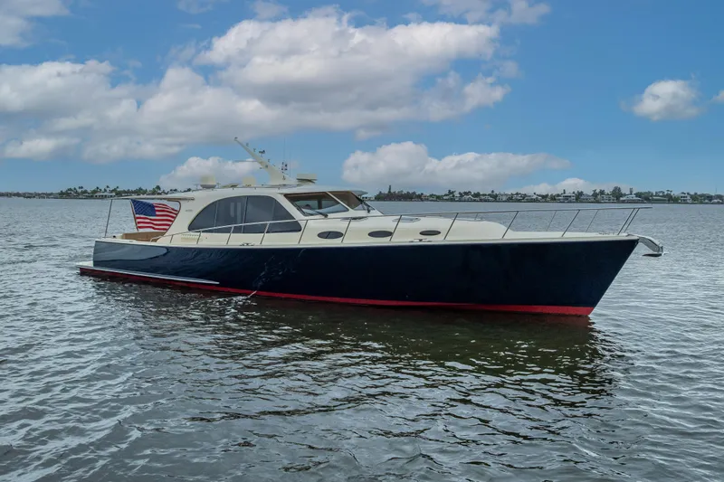 The Image of 2018 Palm Beach Motor Yachts PB55 cruising on calm waters under a blue sky. - 0