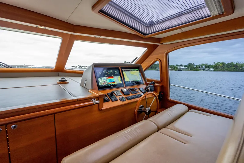 Slide: The Image of 2018 Palm Beach Motor Yachts PB55 helm with navigation screens and leather seating. - 3