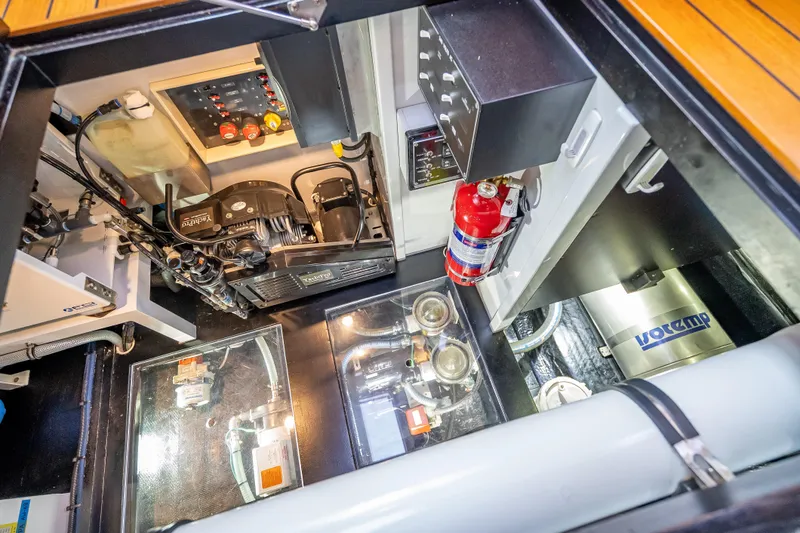 Slide: The Image of Engine room of 2018 Palm Beach Motor Yachts PB55, featuring mechanical components and fire extinguisher. - 54