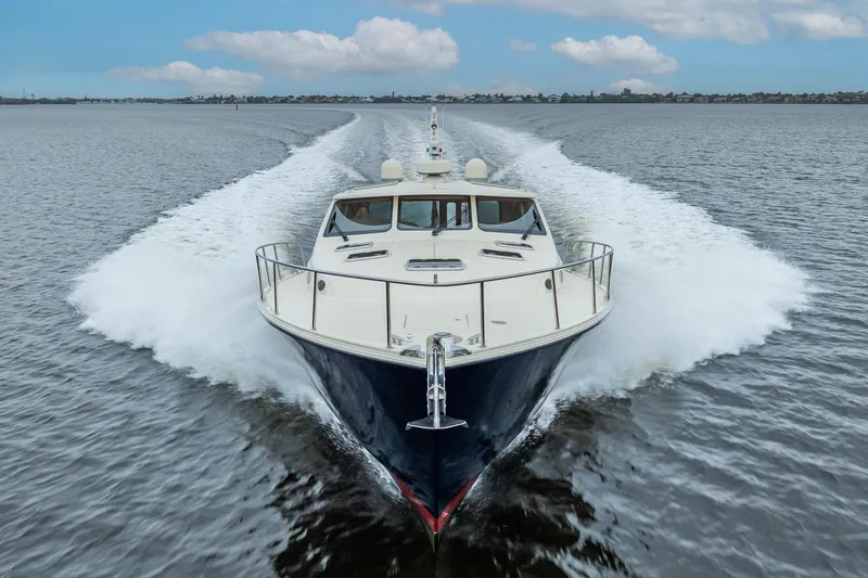 Slide: The Image of 2018 Palm Beach Motor Yachts PB55 cruising on open water, creating a dynamic wake. - 66