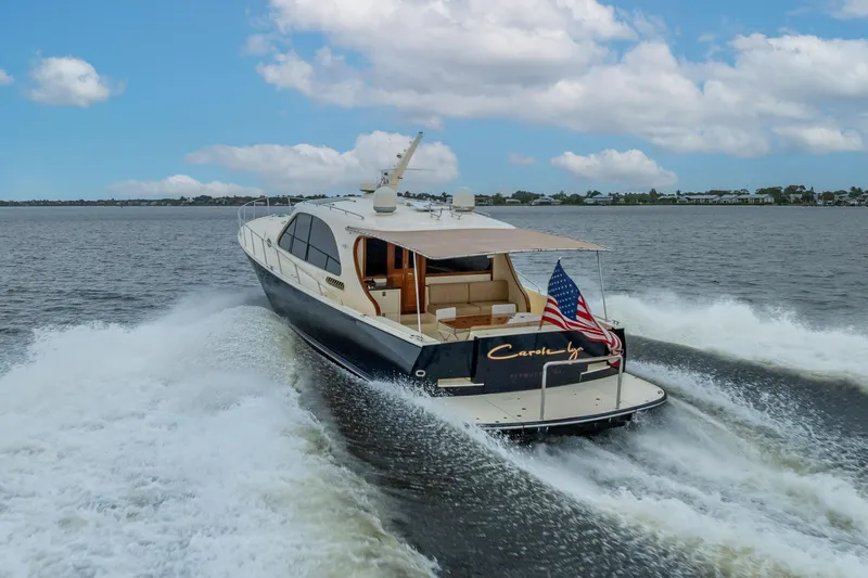 Slide: The Image of 2018 Palm Beach Motor Yachts PB55 cruising on open water under a blue sky. - 7