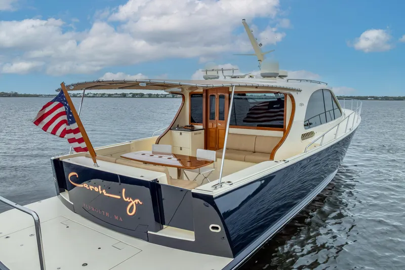 Slide: The Image of 2018 Palm Beach Motor Yachts PB55 on water, featuring elegant design and American flag. - 9