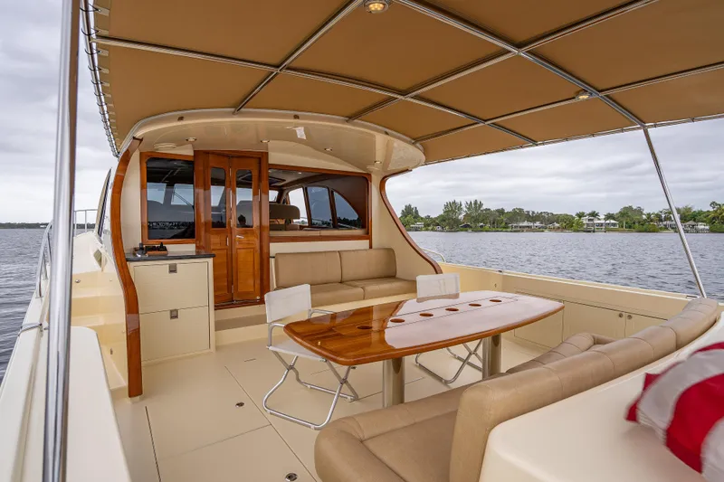 Slide: The Image of 2018 Palm Beach Motor Yachts PB55, elegant interior with seating, table, and water view. - 10