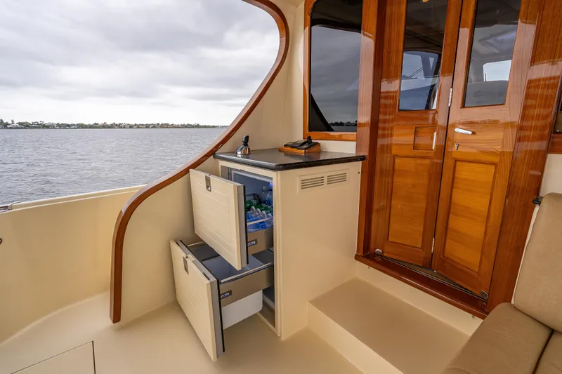 Slide: The Image of Luxurious 2018 Palm Beach Motor Yachts PB55 interior with wooden doors and built-in fridge. - 15