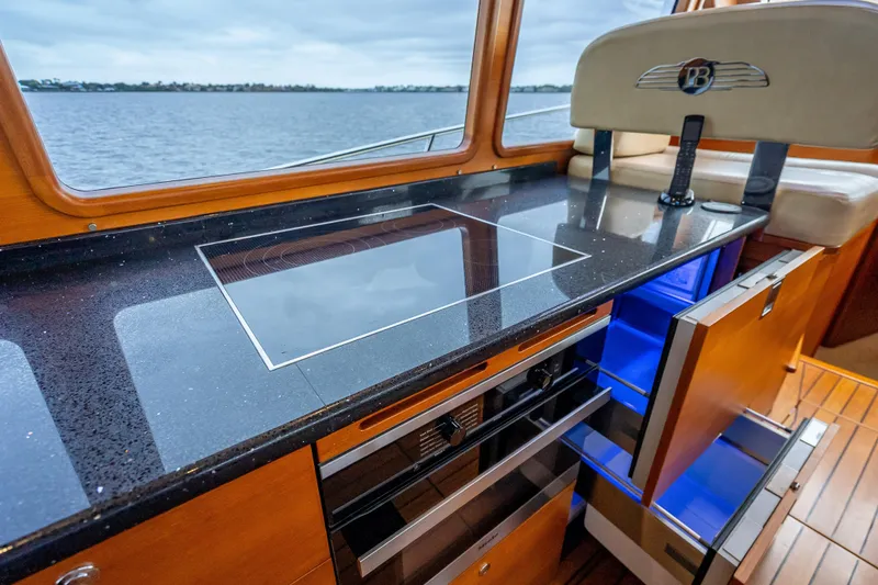 Slide: The Image of Luxurious 2018 Palm Beach Motor Yachts PB55 kitchen with sleek black countertop and modern appliances. - 24