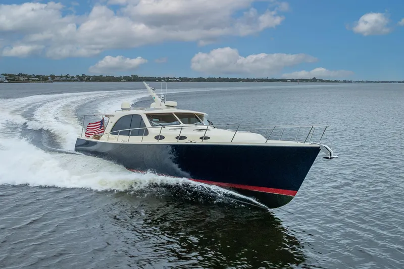 Slide: The Image of 2018 Palm Beach Motor Yachts PB55 cruising on open water under a blue sky. - 5