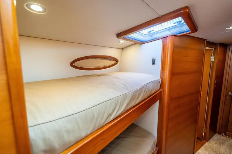 Slide: The Image of 2018 Palm Beach Motor Yachts PB55 interior with wooden bunk beds and soft lighting. - 53
