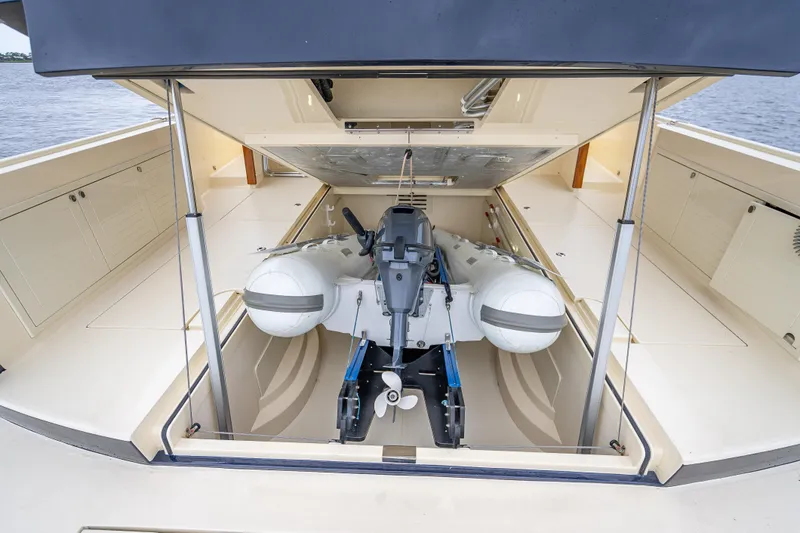 Slide: The Image of 2018 Palm Beach Motor Yachts PB55 with tender storage compartment open, showcasing interior space. - 64