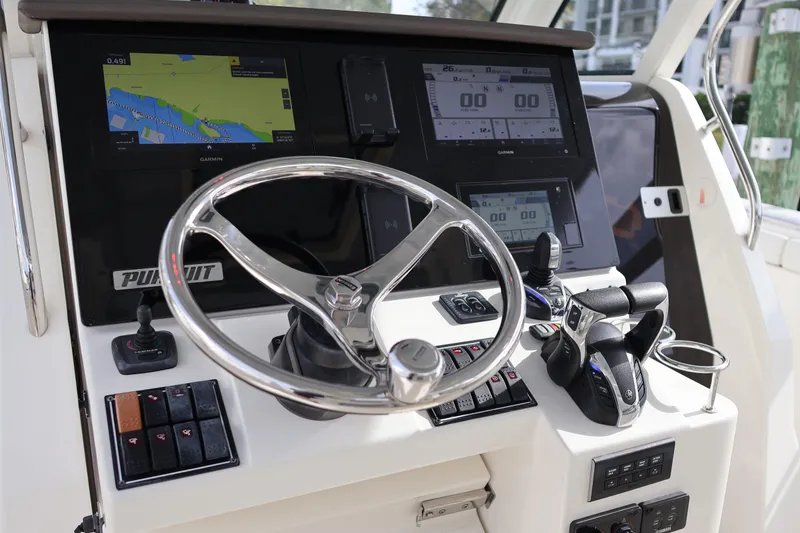 Slide: The Image of 2021 Pursuit S 328 Sport boat dashboard with steering wheel and navigation screens. - 16