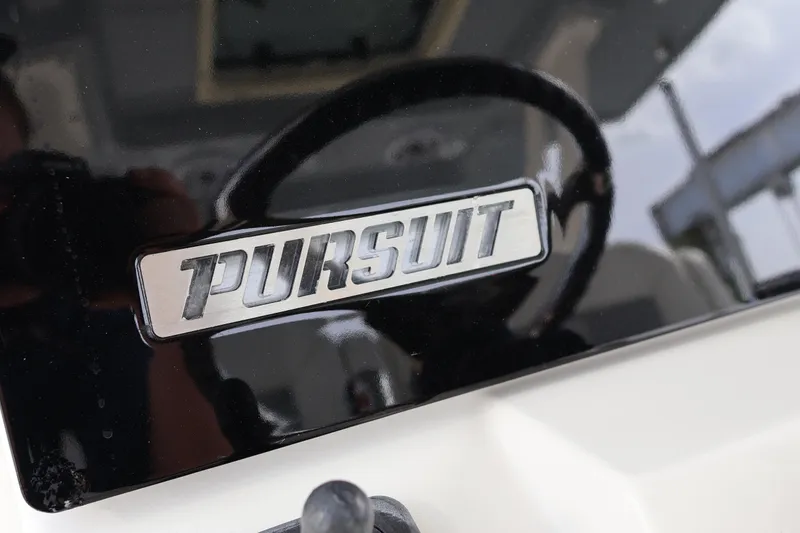 Slide: The Image of 2021 Pursuit S 328 Sport boat logo on glossy black surface. - 23