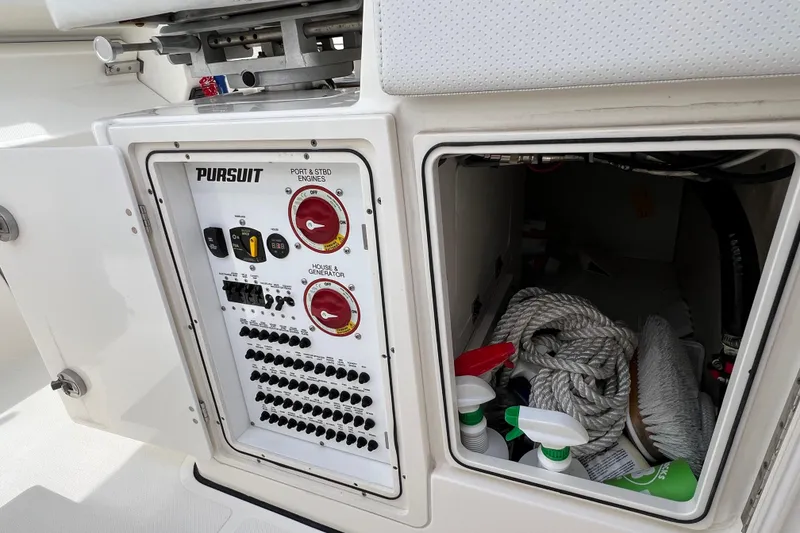 Slide: The Image of Control panel and storage compartment on a 2021 Pursuit S 328 Sport boat. - 24