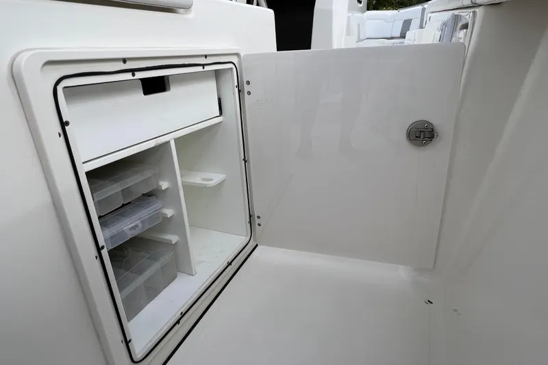 Slide: The Image of Open storage compartment on 2021 Pursuit S 328 Sport boat, featuring organized shelves and containers. - 27