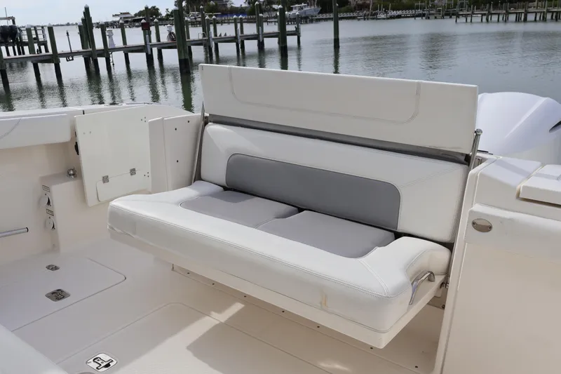 Slide: The Image of 2021 Pursuit S 328 Sport boat with foldable seating by the water. - 31