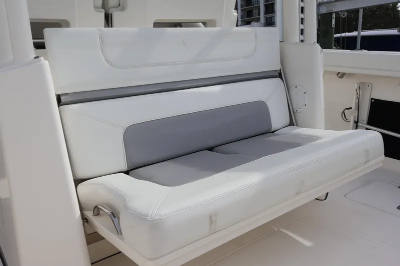 Slide: The Image of 2021 Pursuit S 328 Sport boat interior with white and gray cushioned seating. - 36