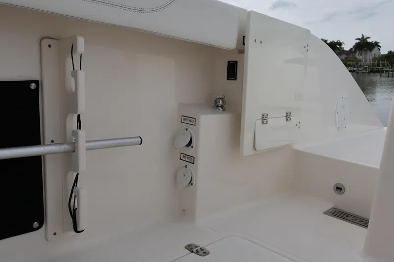 Slide: The Image of 2021 Pursuit S 328 Sport boat interior with storage compartments and water controls. - 43